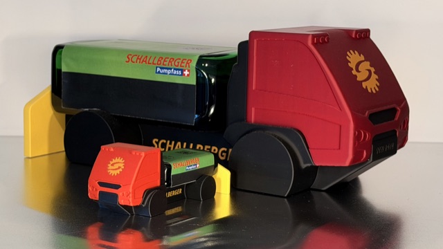 Grosser und kleiner 3D-gedruckter AEBI Transporter mit roter Kabine, Jägermeister-Flasche und gelbem Anbauteil